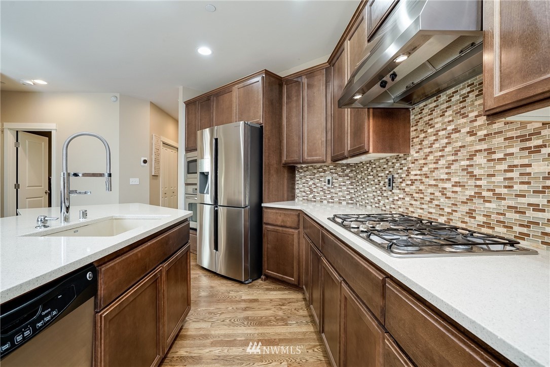 3408 223rd Place Southeast Bothell, WA 98021 - Photo 11 of 40 a kitchen with stainless steel appliances granite countertop a sink stove and refrigerator