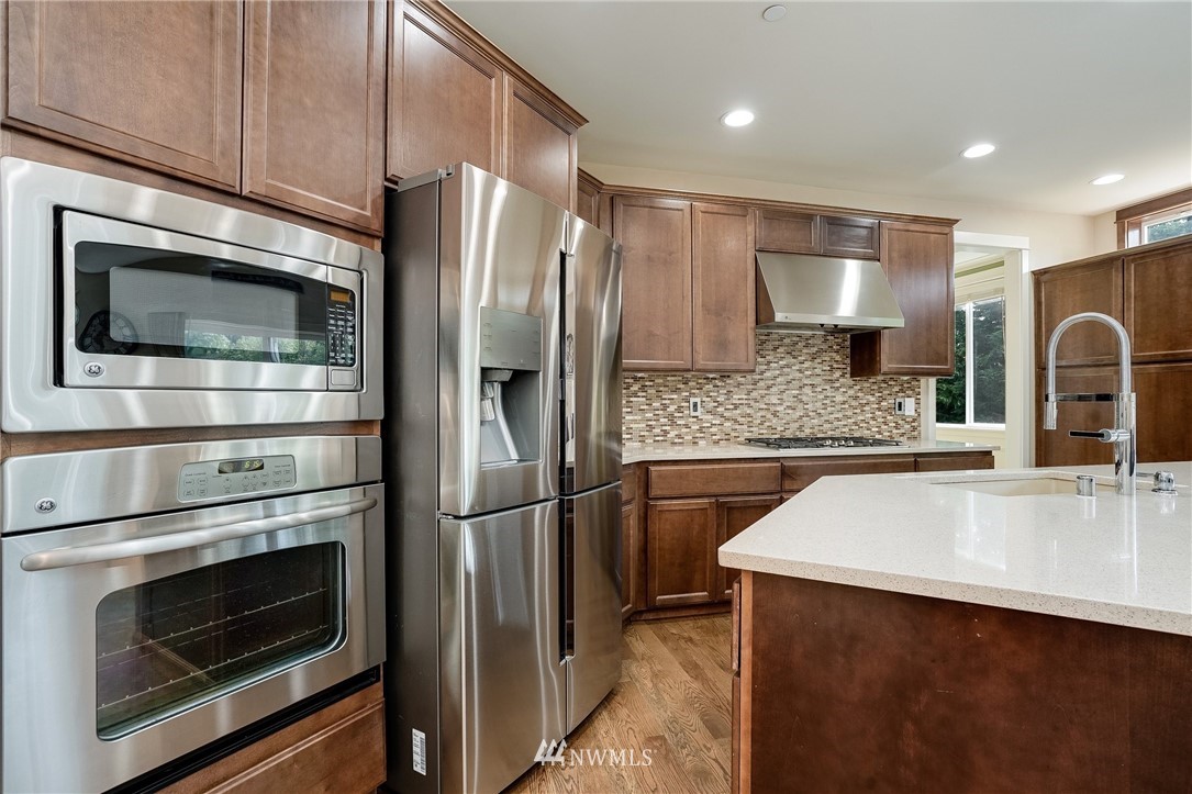 3408 223rd Place Southeast Bothell, WA 98021 - Photo 9 of 40 a kitchen with stainless steel appliances a refrigerator stove and microwave