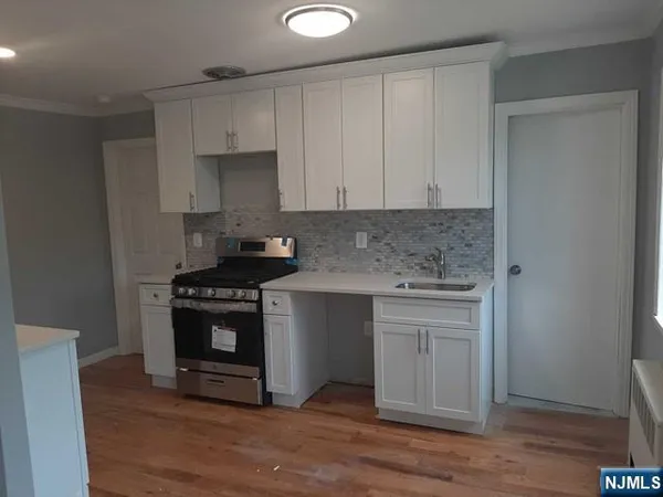 a kitchen with granite countertop a stove and a sink