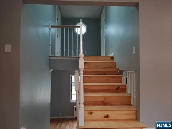 a view of staircase with wooden floor and cabinet