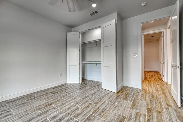 a view of empty room with wooden floor