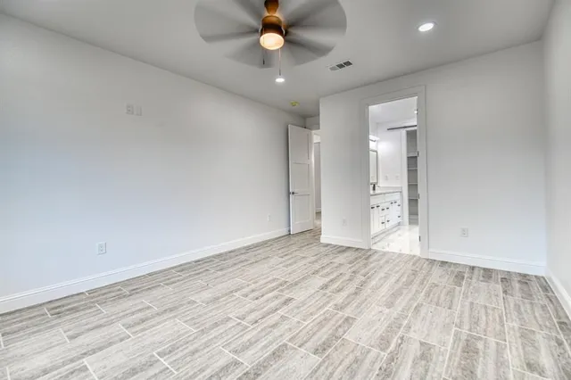 wooden floor in an empty room with a ceiling fan