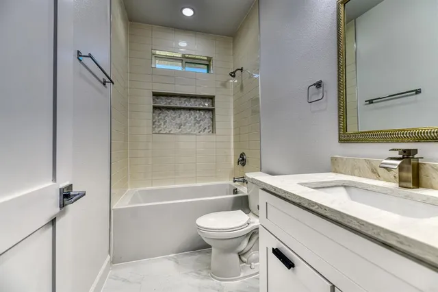 a bathroom with a granite countertop toilet sink and a mirror