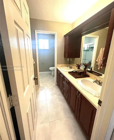 a bathroom with a double vanity sink a mirror and a bathtub