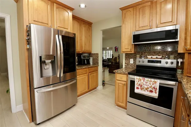 a bathroom with a granite countertop sink toilet mirror and bathtub