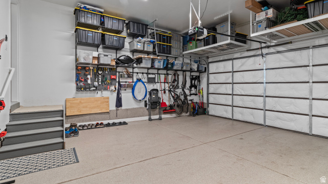 355 East Overlook Loop Hideout, UT 84036 - Photo 38 of 40 Garage space with outlet for EV charging, extensive wall-mounted storage systems, overhead shelving, and a durable epoxy-coated concrete floor.