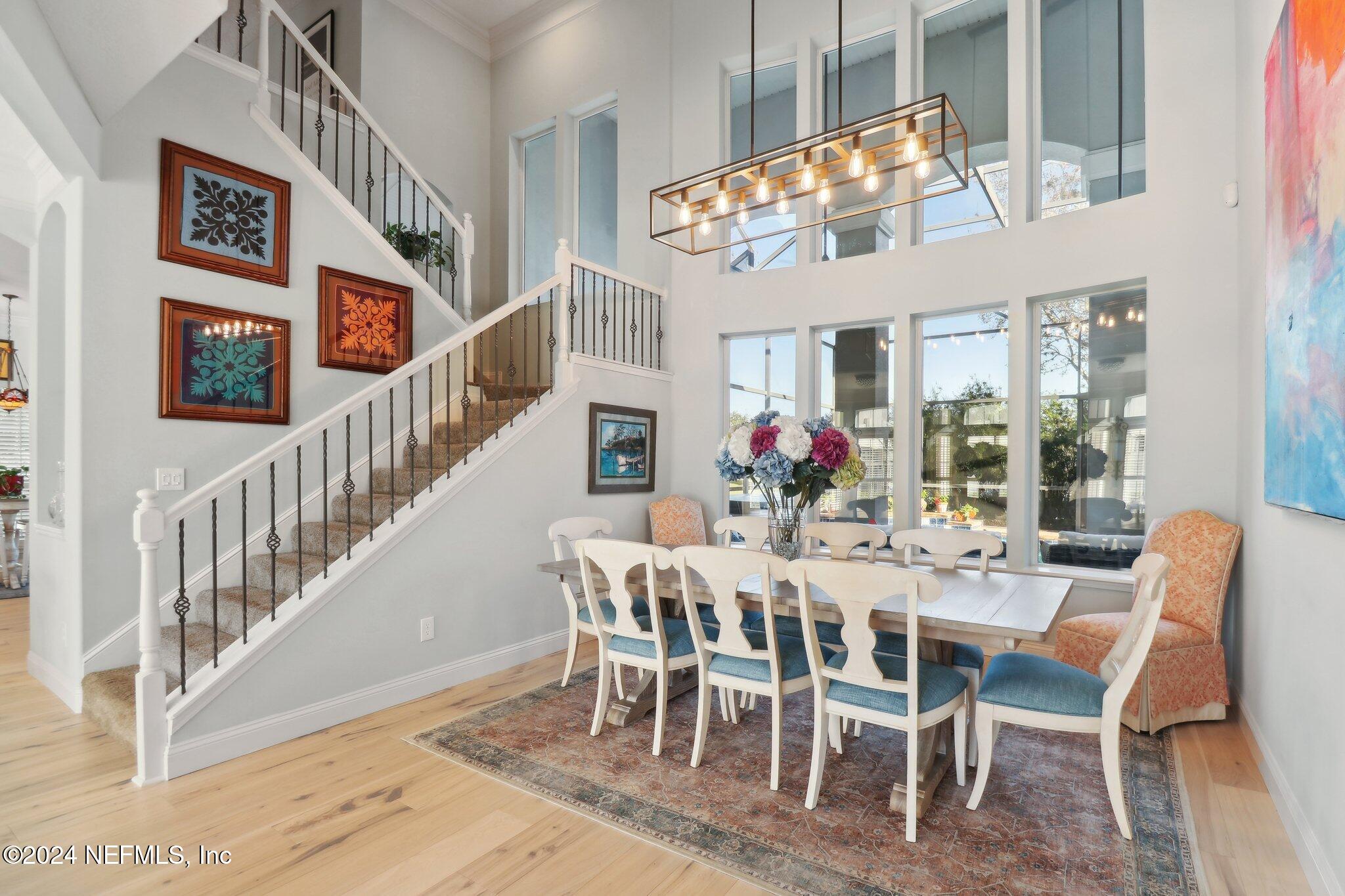 240 Pinehurst Pointe Drive St. Augustine, FL 32092 - Photo 11 of 70 a view of a dining room with furniture a chandelier and wooden floor