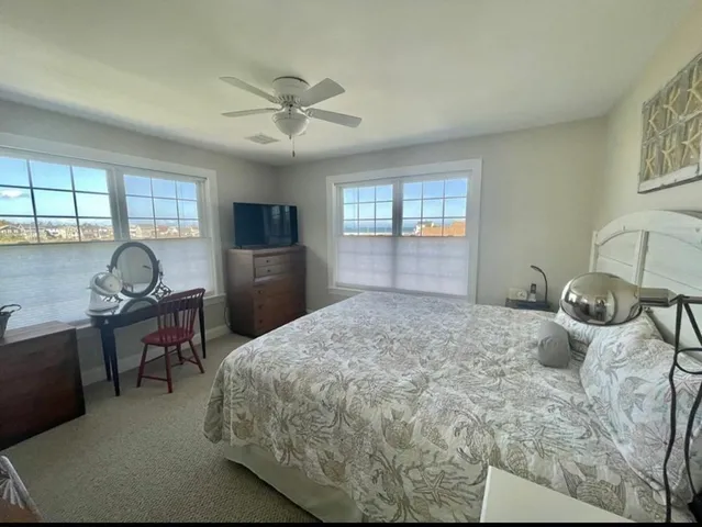 a bedroom with a bed and a dresser next to a window