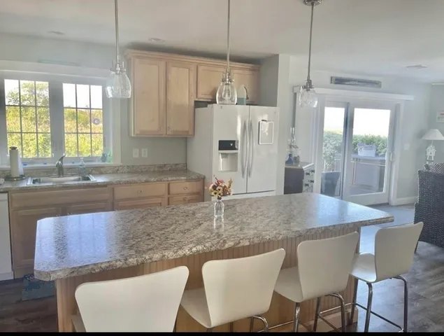 a kitchen with stainless steel appliances granite countertop a table chairs and a sink