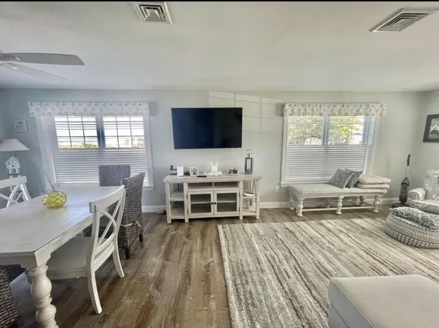 a living room with furniture a flat screen tv and a floor to ceiling window