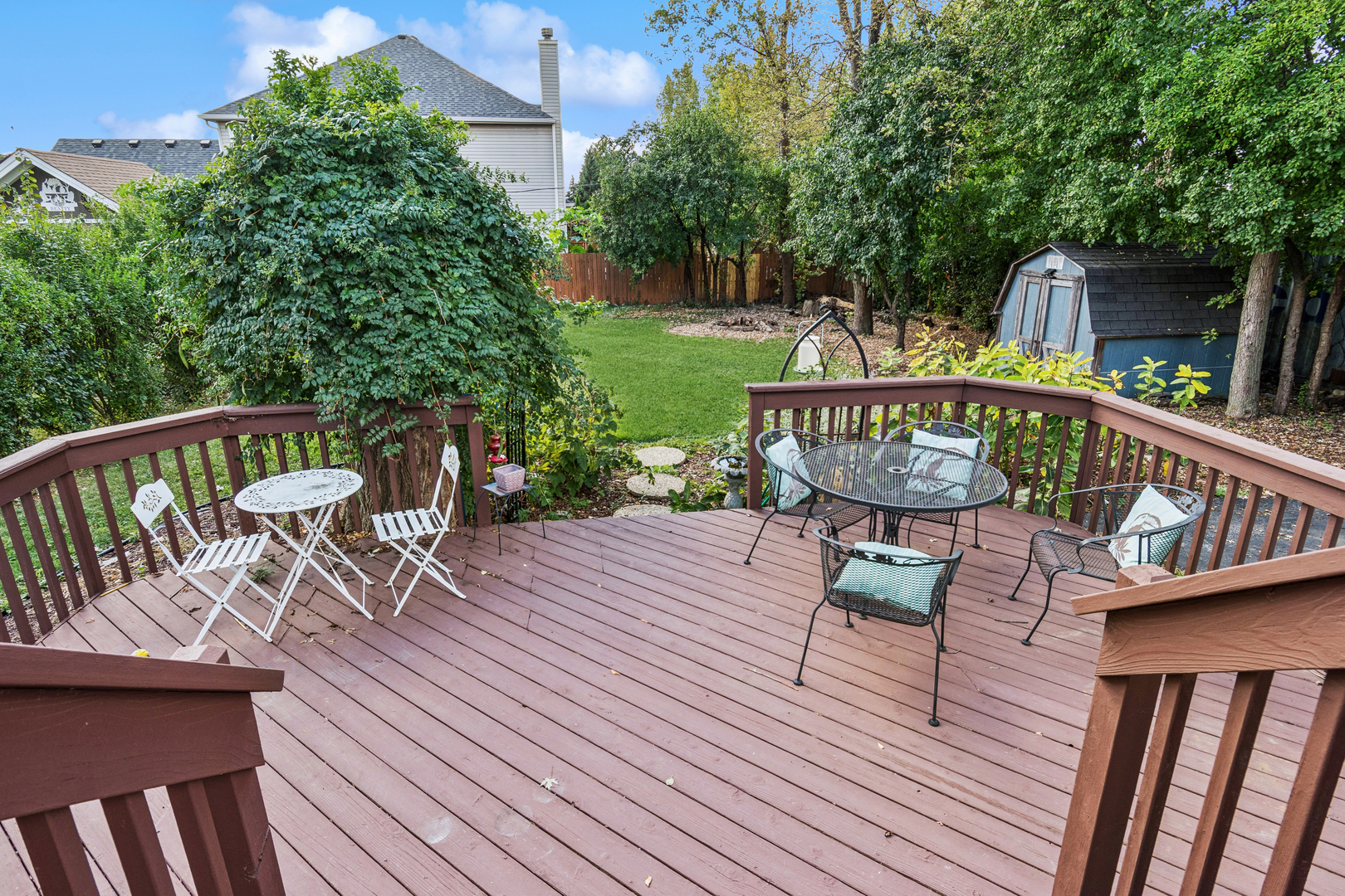 25W361 Doris Avenue Carol Stream, IL 60188 - Photo 17 of 25 a view of a roof deck with table and chairs a barbeque with wooden floor and fence
