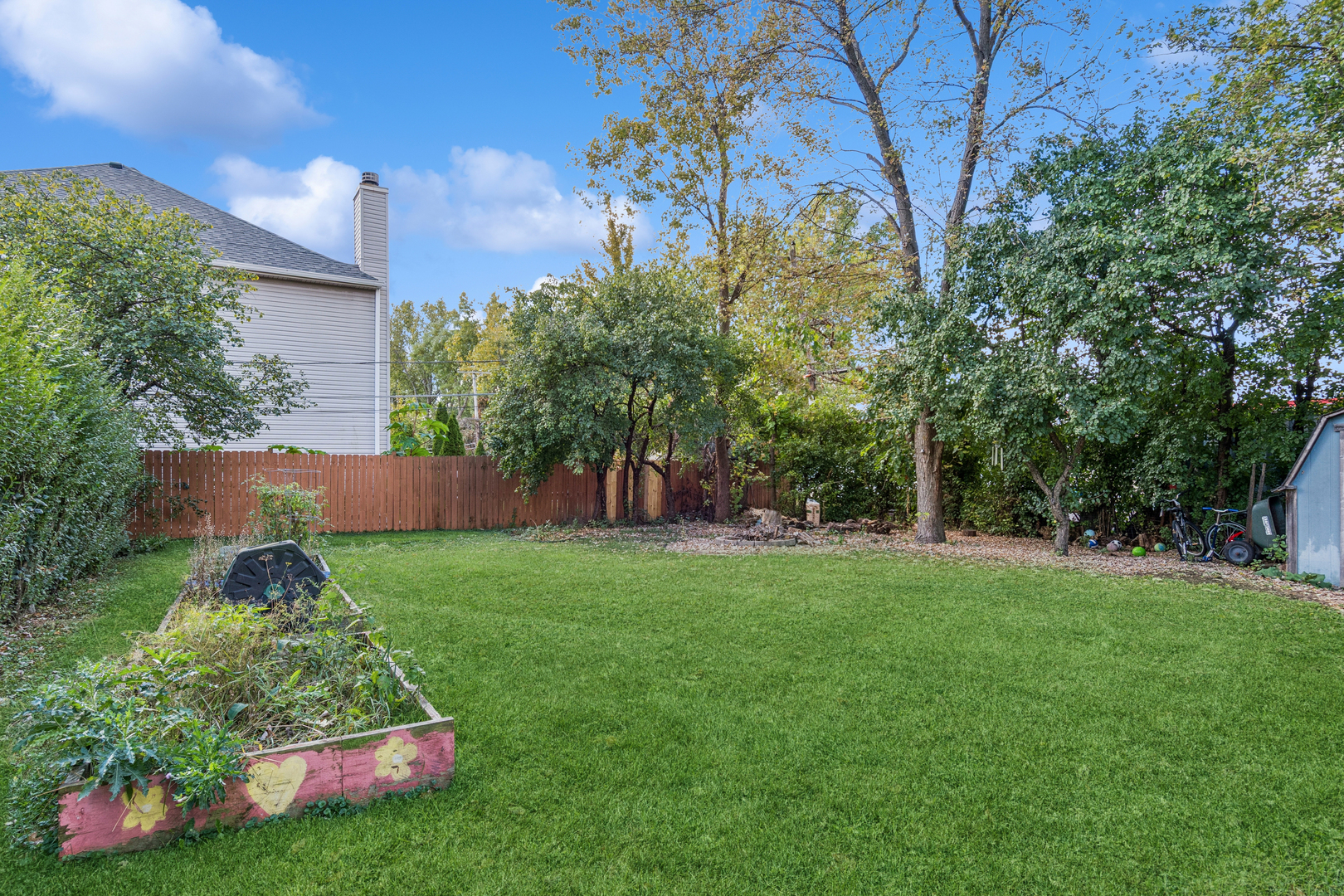 25W361 Doris Avenue Carol Stream, IL 60188 - Photo 18 of 25 a view of a backyard with potted plants and large trees