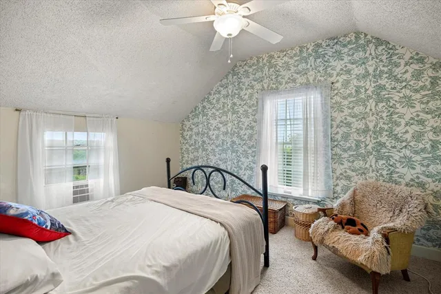 a bedroom with a bed couch and window