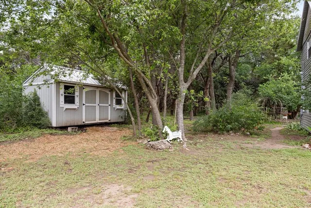 a view of a house with backyard and trees