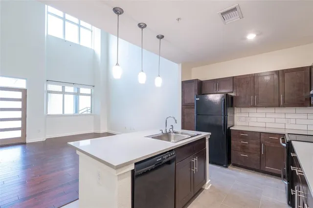 a kitchen with a refrigerator a sink and wooden cabinets