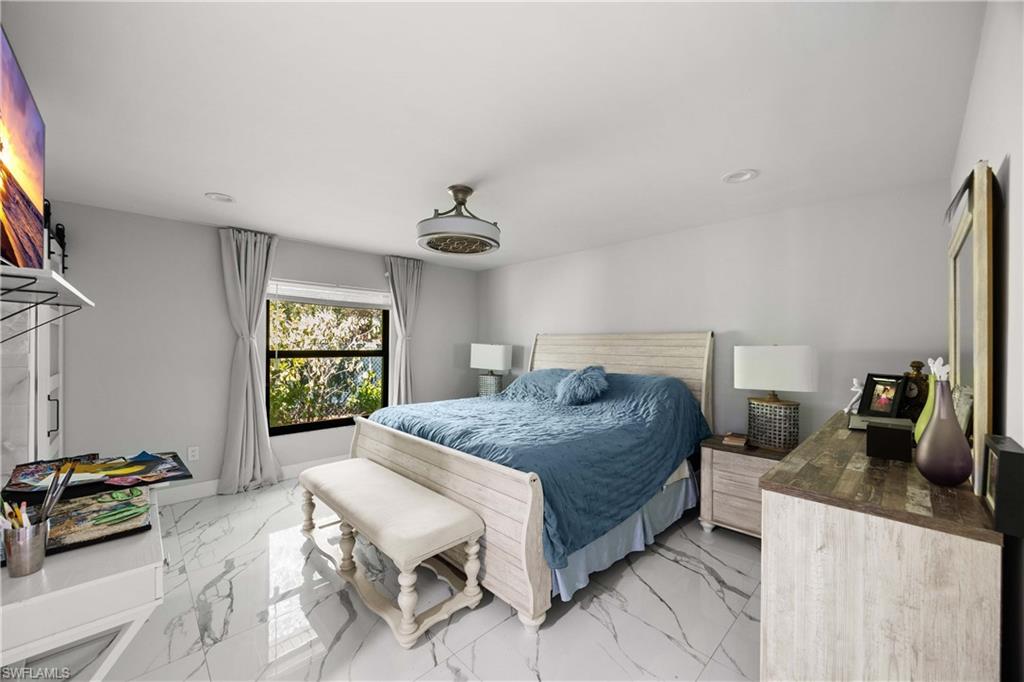 1890 Oakes Boulevard, Unit A Naples, FL 34119 - Photo 13 of 50 a bedroom with a bed a couch and dresser