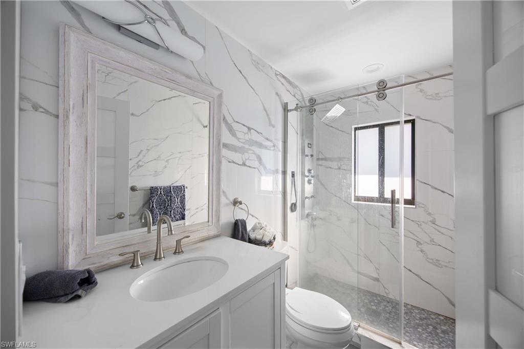 1890 Oakes Boulevard, Unit A Naples, FL 34119 - Photo 17 of 50 a bathroom with a sink toilet a mirror and shower