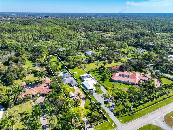an aerial view of a residential houses with a yard