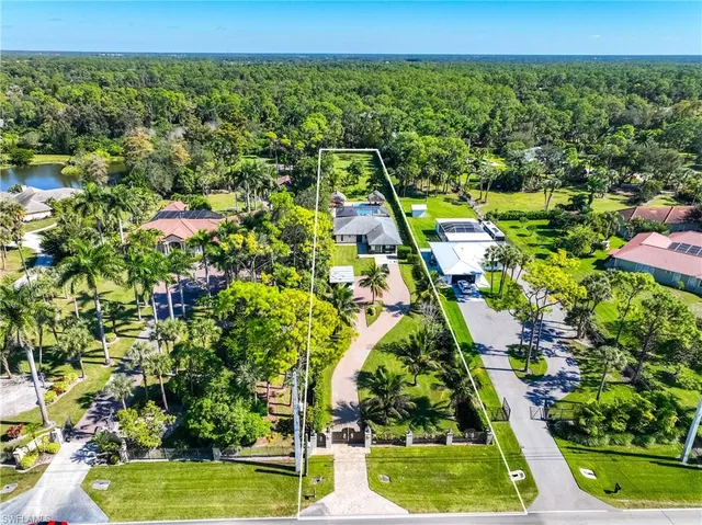 an aerial view of residential houses with outdoor space and trees