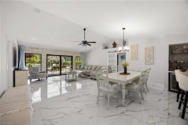 a living room with furniture a chandelier and a flat screen tv