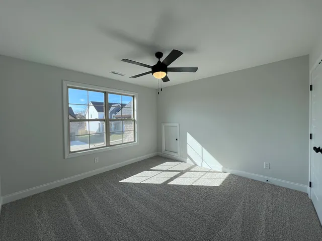 a bathroom with a glass shower door and a window