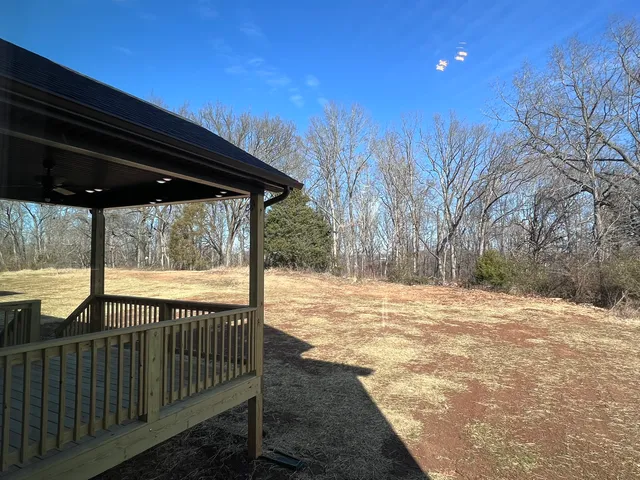 a living room with furniture a table and kitchen view