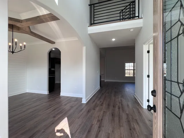 a view of an empty room with wooden floor fireplace and a window
