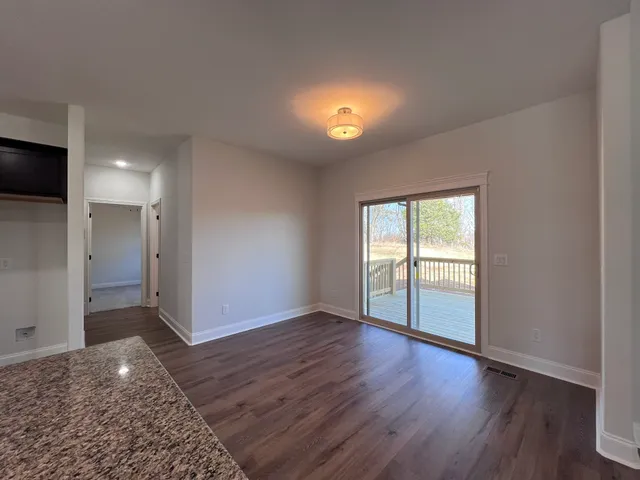 a bathroom with a granite countertop double vanity sink a mirror and a bathtub