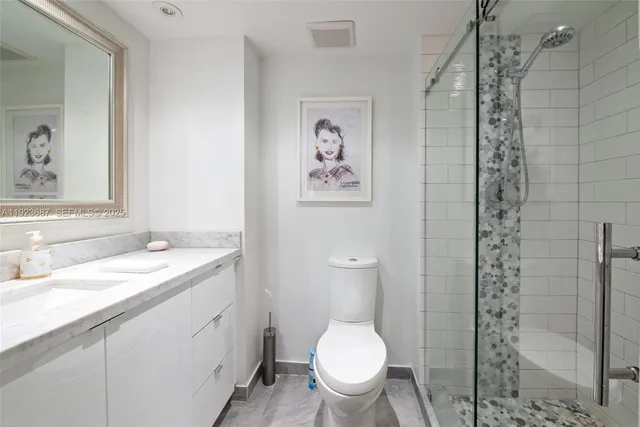 a bathroom with a granite countertop sink toilet and shower
