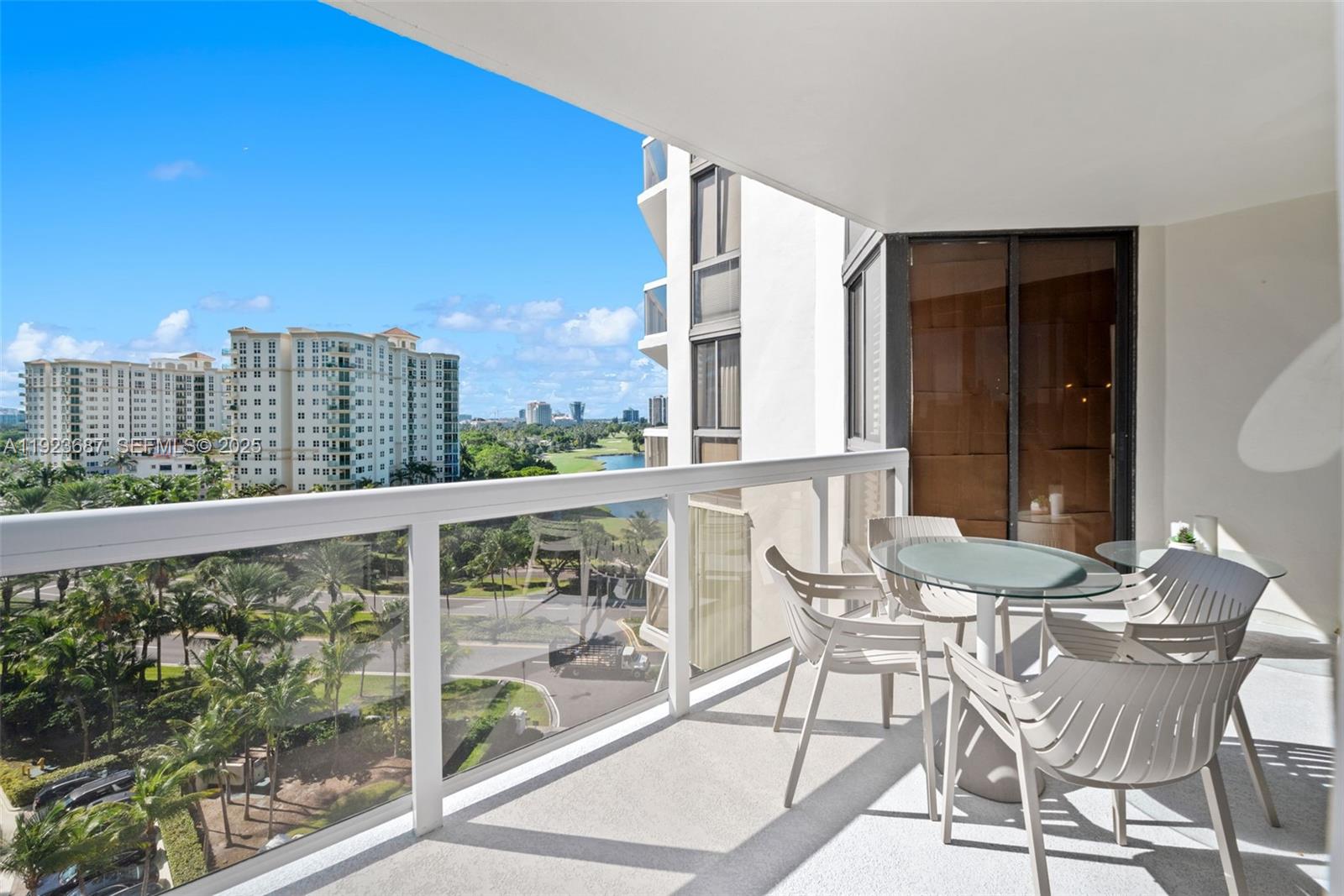 20185 East Country Club Drive, Unit 904 Aventura, FL 33180 - Photo 19 of 29 a view of a balcony with a table and chairs and wooden fence