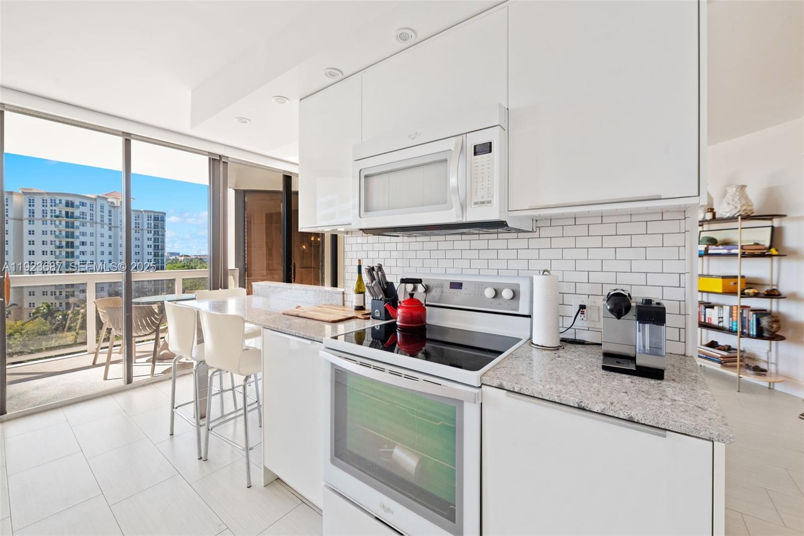 20185 East Country Club Drive, Unit 904 Aventura, FL 33180 - Photo 4 of 29 a kitchen with a stove a sink and a microwave