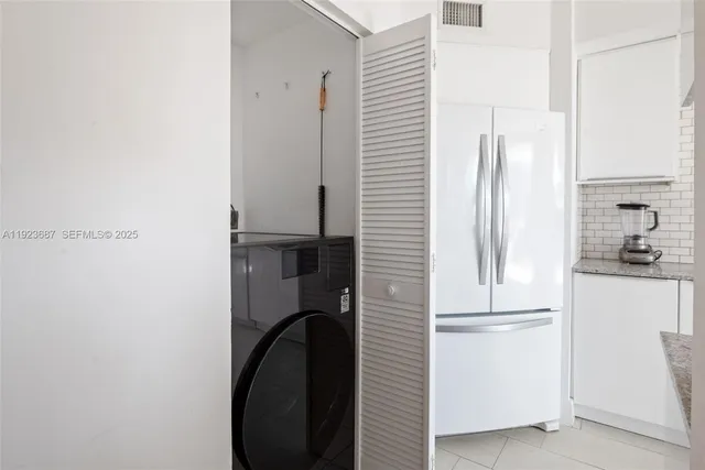 a kitchen with a refrigerator and white cabinets