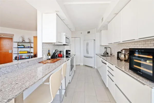 a large kitchen with stainless steel appliances granite countertop a lot of counter space and wooden floor