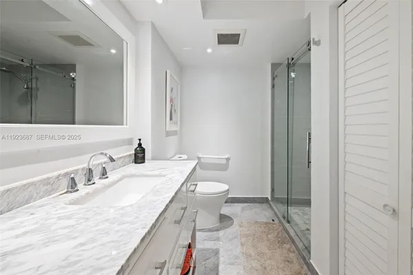 a bathroom with a granite countertop sink toilet and shower