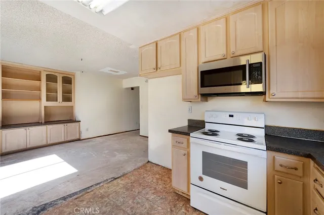a kitchen with stainless steel appliances granite countertop a stove microwave and cabinets