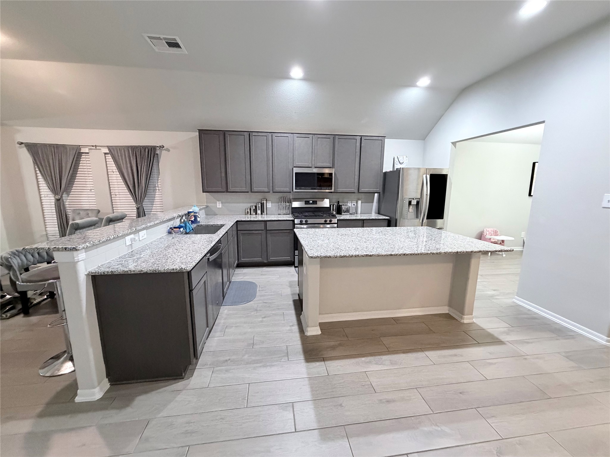 4303 Greeley Lane Rosenberg, TX 77471 - Photo 26 of 30 a kitchen with stainless steel appliances granite countertop a stove a sink and a microwave