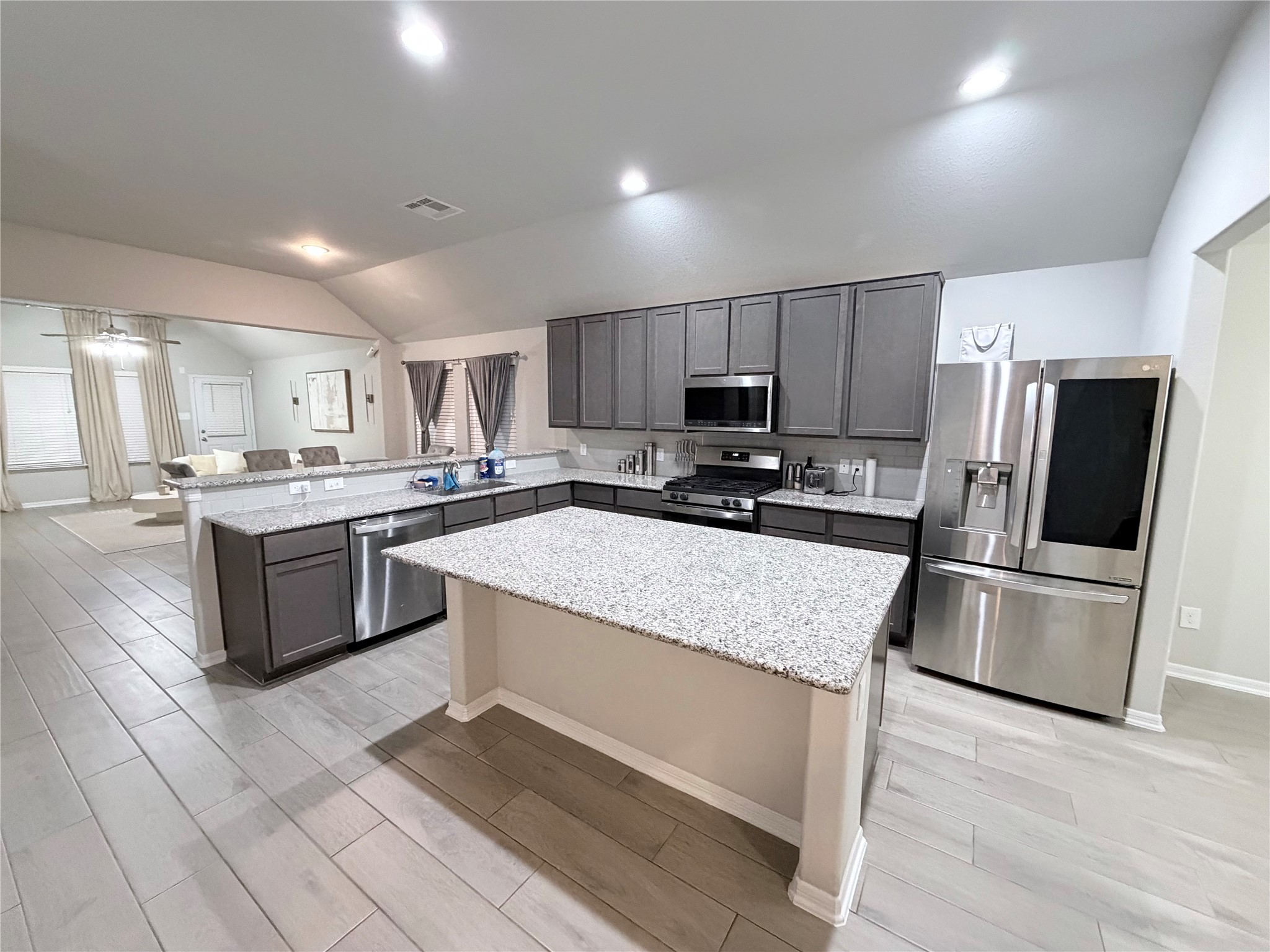 4303 Greeley Lane Rosenberg, TX 77471 - Photo 27 of 30 a kitchen with stainless steel appliances granite countertop a refrigerator a stove a sink a microwave and white cabinets