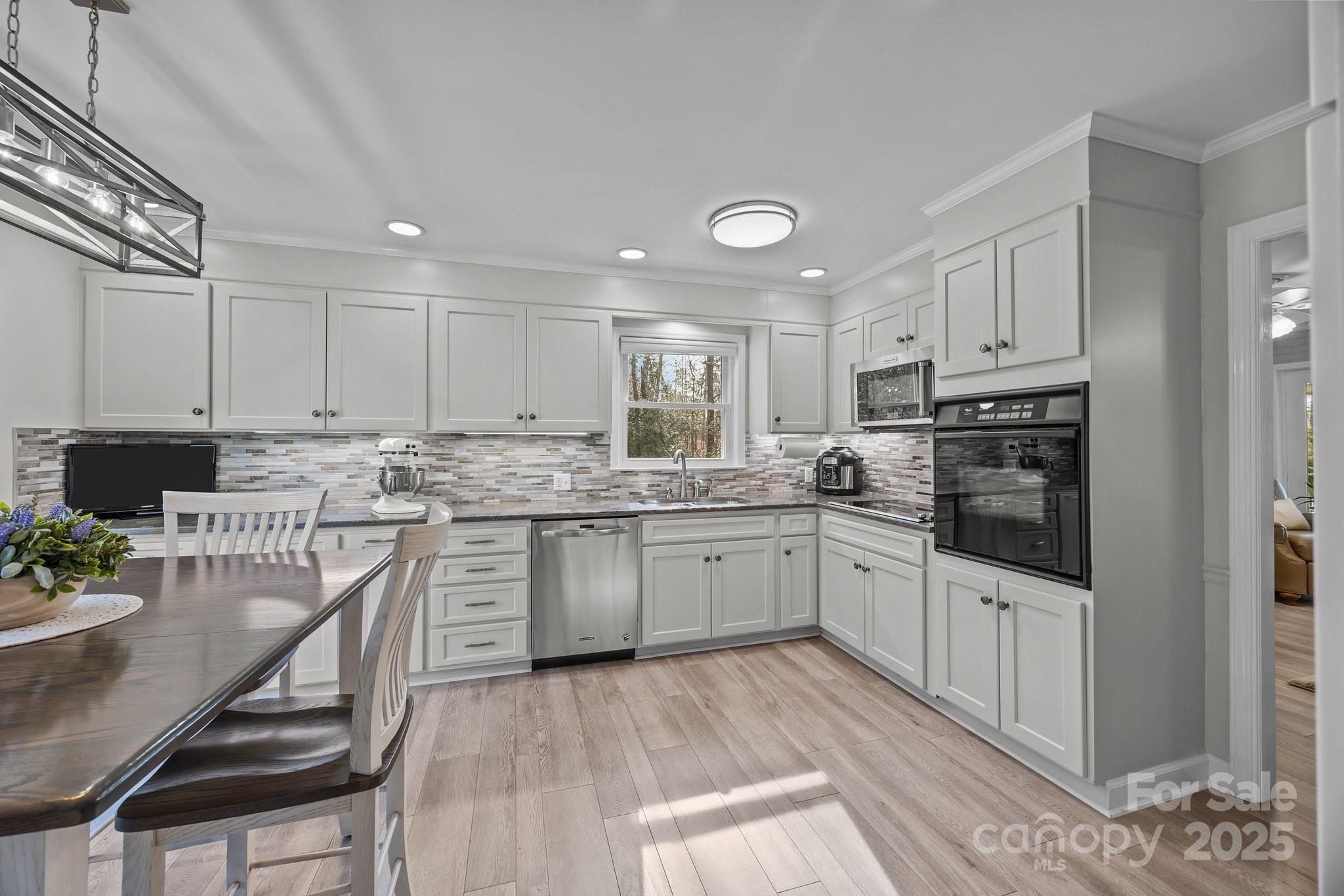 520 Mainsail Road Salisbury, NC 28146 - Photo 11 of 47 a kitchen with granite countertop white cabinets and white appliances