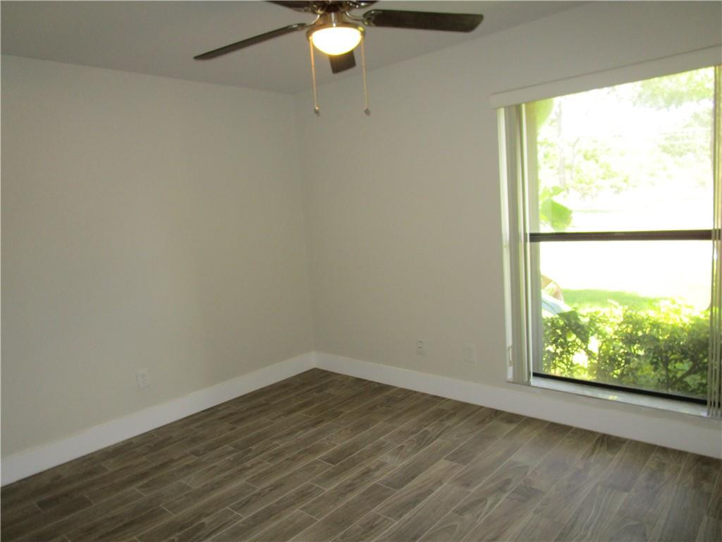 8205 Boca Rio Drive, Unit 8205 Boca Raton, FL 33433 - Photo 11 of 17 an empty room with wooden floor and windows