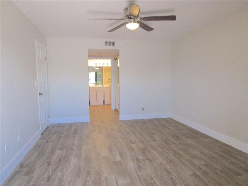 8205 Boca Rio Drive, Unit 8205 Boca Raton, FL 33433 - Photo 7 of 17 an empty room with wooden floor fan and windows