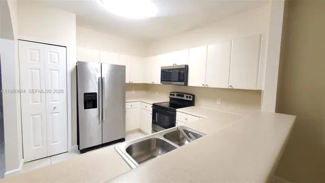 a kitchen with stainless steel appliances a refrigerator a stove a microwave and a refrigerator