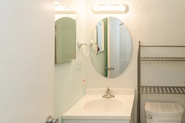 a bathroom with a sink a toilet and a mirror