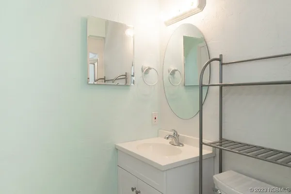 a bathroom with a sink mirror and toilet