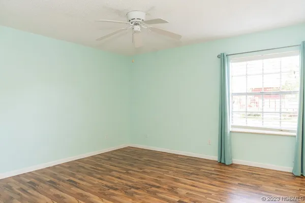 an empty room with a window and a ceiling fan