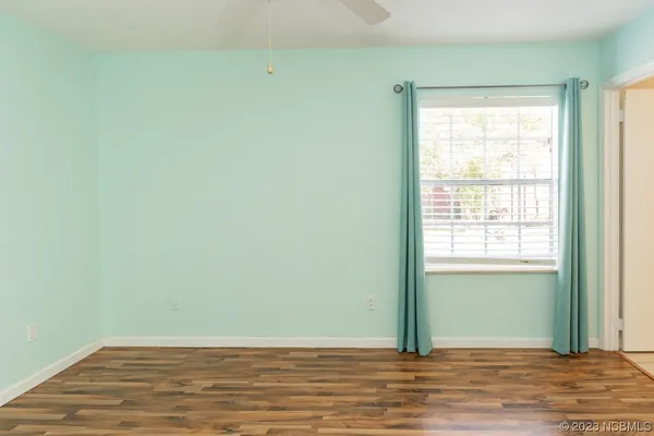 a view of a room with wooden floor and a window