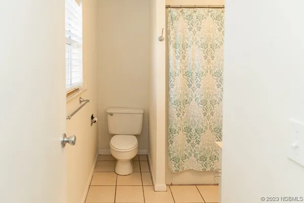 a bathroom with a toilet and a shower curtain