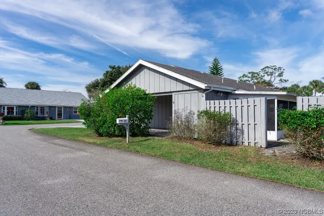 a front view of a house with a yard and potted plants