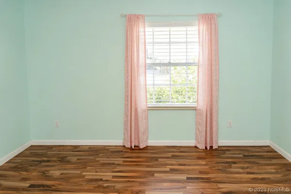 a view of a room with wooden floor and window
