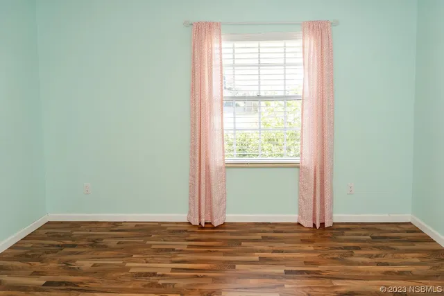 a view of a room with wooden floor and window