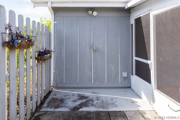 a view of a hallway to a livingroom with wooden floor and stairs